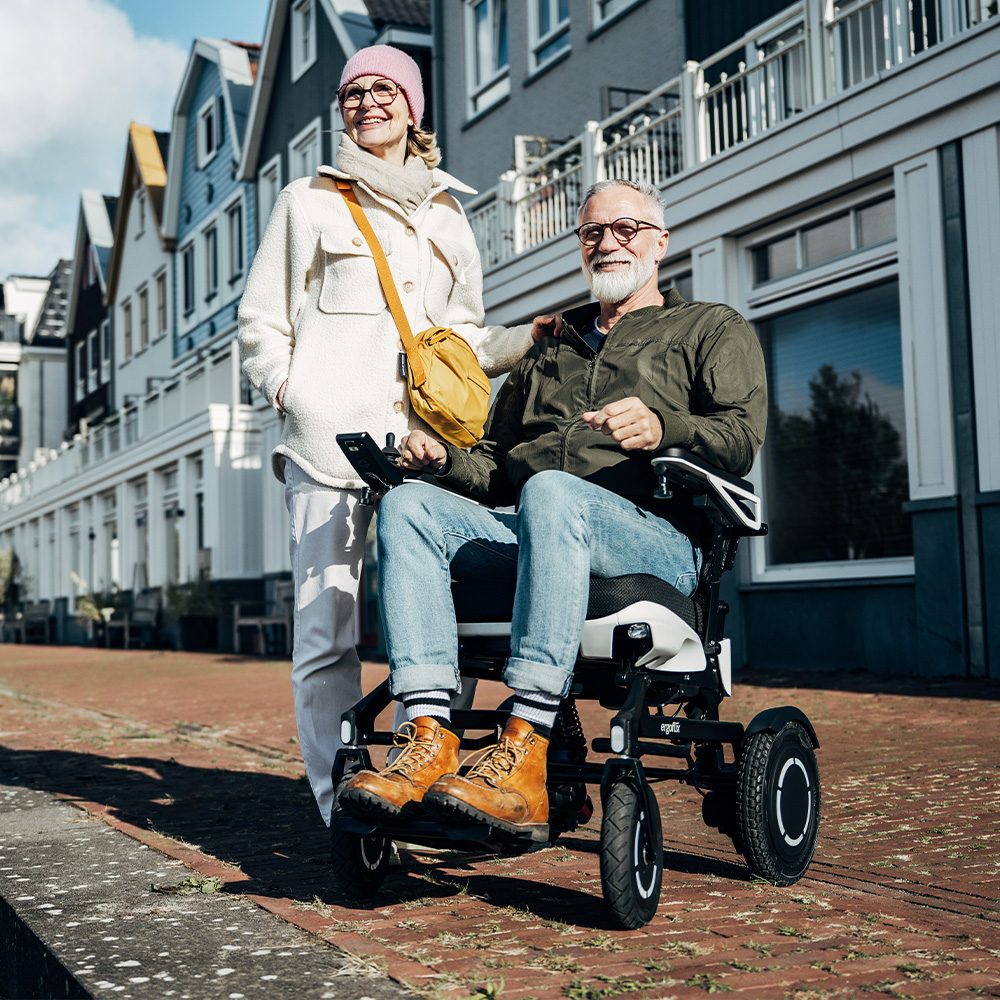 Ein Senior sitzt im ergoflix vario und schaut mit einer Seniorin in die Ferne.
